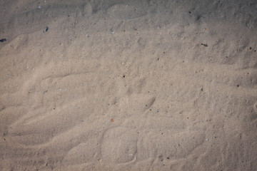 Wave of the sea on the sand beach, summer sand beach background with footprint