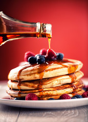 Pancakes with berries and maple syrup.