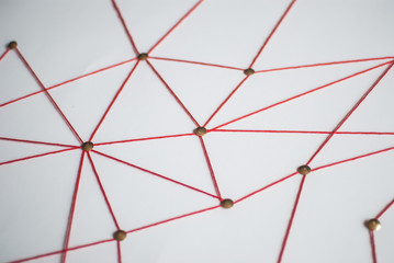 Background. Abstract concept (idea) of network, social media, internet, teamwork,  communication. Thumbtacks linked together by red thread. Isolated. Entities connected.