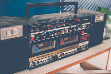 Retro dusty boombox (tape recorder) on a shelf in a garage