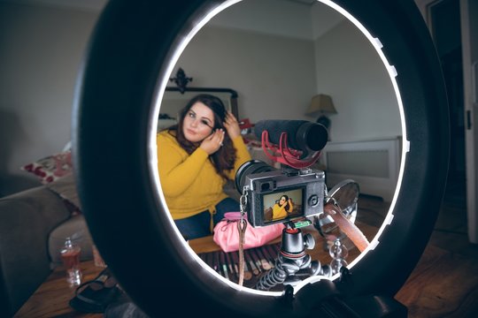Beautiful female vlogger applying mascara
