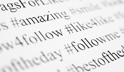 Closeup of typed popular hashtags. Words on the paper sheet. Abstract concept of social media,...