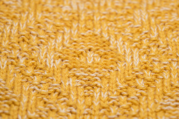 Yellow melange knitted fabric of sweater, macro pattern of handmade knitted clothing of cotton yarn