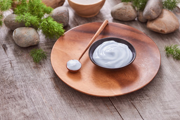 Preparing handmade hydrating natural gel and anti-aging cosmetic from extract of aloe vera leaves with pebbles and wooden background for zen beauty, top view