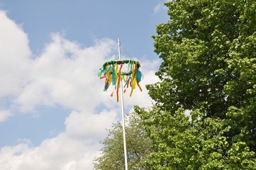 Ein Maibaum und Pfingstbaum mit bunten Bändern hübsch geschmückt 