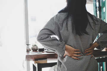 Businesswoman suffering from pain of lower back