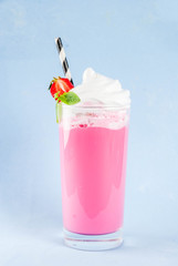 Cold strawberry  milkshake with fresh berries and mint isolated on light blue background copy space