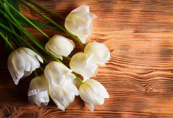 Fototapeta na wymiar White tulips over old wood background