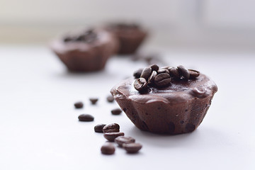 Chocolate fondant lies on a white background sprinkled with coffee beans