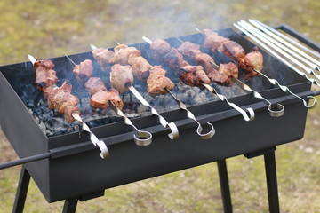 Meat on skewers fried on the grill in the garden.
