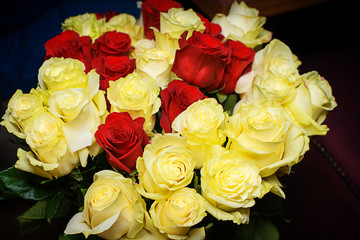 Bouquets of red and yellow roses on a wooden table