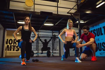  Two young and fit girls are exercising in gym with their personal trainer © Nebojsa