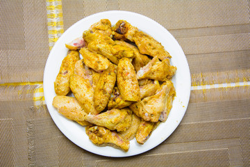 a lot of fried chicken wings in a white plate