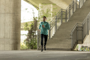 Fototapeta na wymiar Young man running in urban enviroment