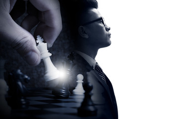 The double exposure image of the businessman standing overlay with chess game image and white copy...
