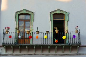El balcón tiene muchos adornos de colores y macetas.