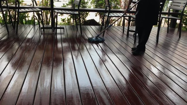 Maid cleaning wooden floor.
