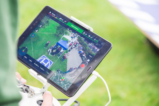 A live video from a drone to a tablet where the pilot is visible piloting the drone 