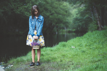 Happy teen girl in the forest with flowers