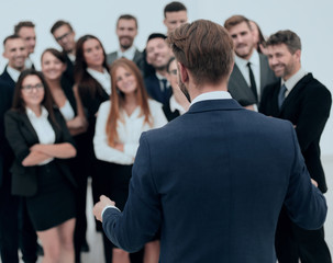 businessman makes a speech to his large business team