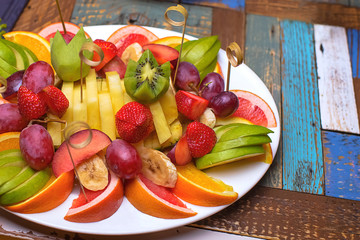 The fruit on the plate. Sliced fruits on plate on colorful table