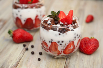 Strawberry Cake in Glass with White Crea mans Strawberry. Homemade summer dessert on white rustic table.