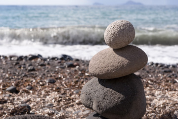 Fototapeta na wymiar Stones pyramid on pebble beach symbolizing zen, balance