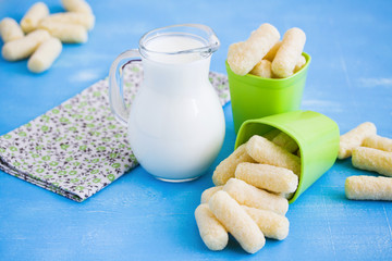 Milk jug and sweet corn sticks with sugar powder.
