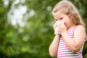 Girl with allergy cleaning nose