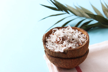 fresh coconut shavings and palm leaf on a colored background.
