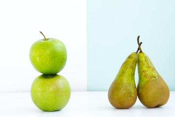 the composition of two green apples and two ripe green pears, on differet backgrounds