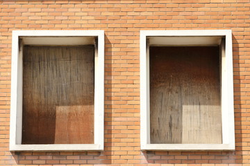 de  vieilles fenetres avec panneaux de bois qui ont besoin d'une rénovation sur une maison de brique