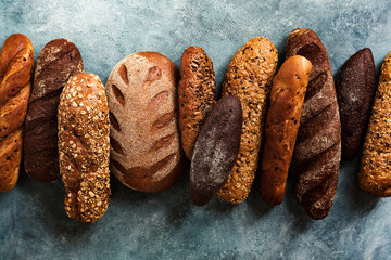 Different types fresh bread on a blue background. Top view
