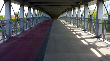 Covered pedestrian-bicycle footbridge, without people.