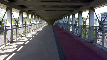 Covered pedestrian-bicycle footbridge, without people.