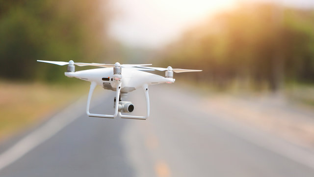 Drone copter flying with digital camera in the park.