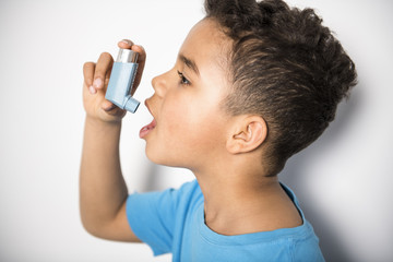 black Boy using an asthma inhaler - obrazy, fototapety, plakaty