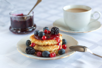 syrniki with berries, and jam, and coffee with milk