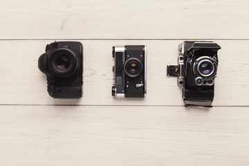 Three different cameras on white table