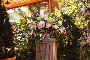 Fototapeta na wymiar Bouquet of different Flowers in rustic style on a wooden pedestal at the wedding ceremony
