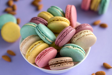 Fototapeta na wymiar Colorful macarons in bowls. Close-up of multicolored sweet pastries of macaron filling ceramic bowl.
