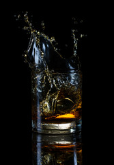 Splash in transparent glass of whiskey