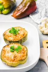 Chicken alfredo stuffed peppers in baking dish on light concrete background. Selective focus, copy space.