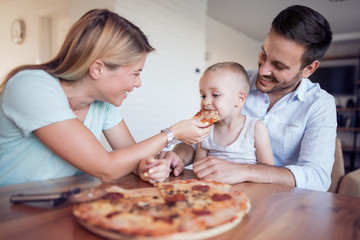 Happy family eat pizza at home
