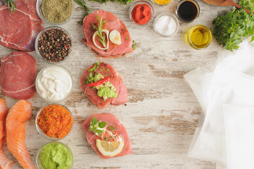 Beef, salmon, spice, greens and plastic bag for sous vide cooking.