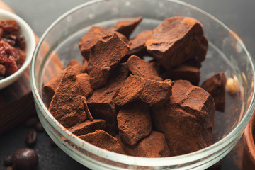 Crushed chocolate pieces in bowl on black background