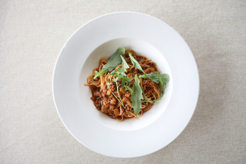 spaghetti Bolognese with minced beef and tomato sauce garnished with parmesan cheese and basil , Italian food