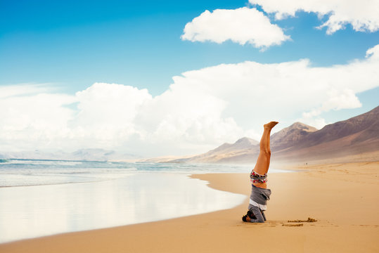 Woman doing headstand on beach, Corralejo, Fuerteventura, Canary Islands