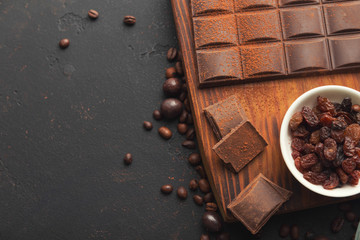 Crushed chocolate pieces and raisons on gray background