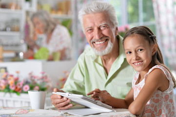 grandfather with granddaughter using laptop